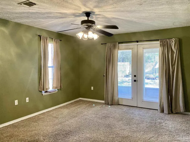 an empty room with closet and windows