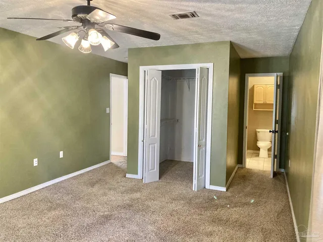 a view of a room with a chandelier fan and closet