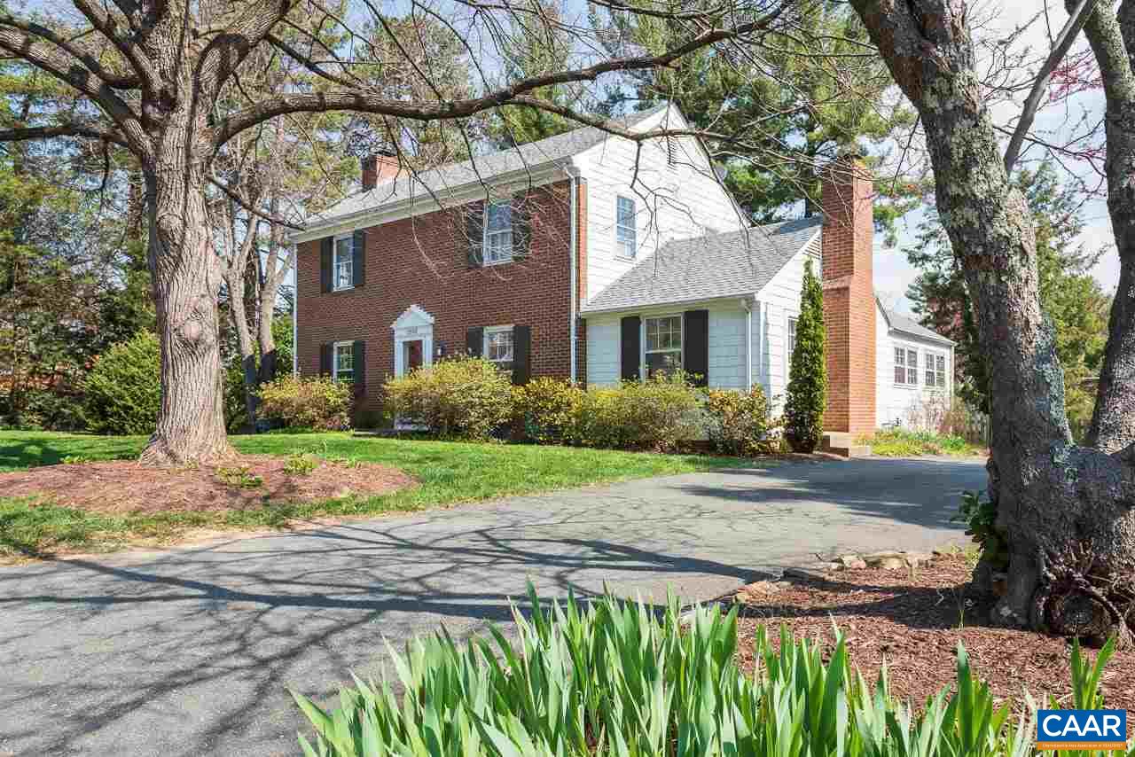 a front view of a house with a yard and trees
