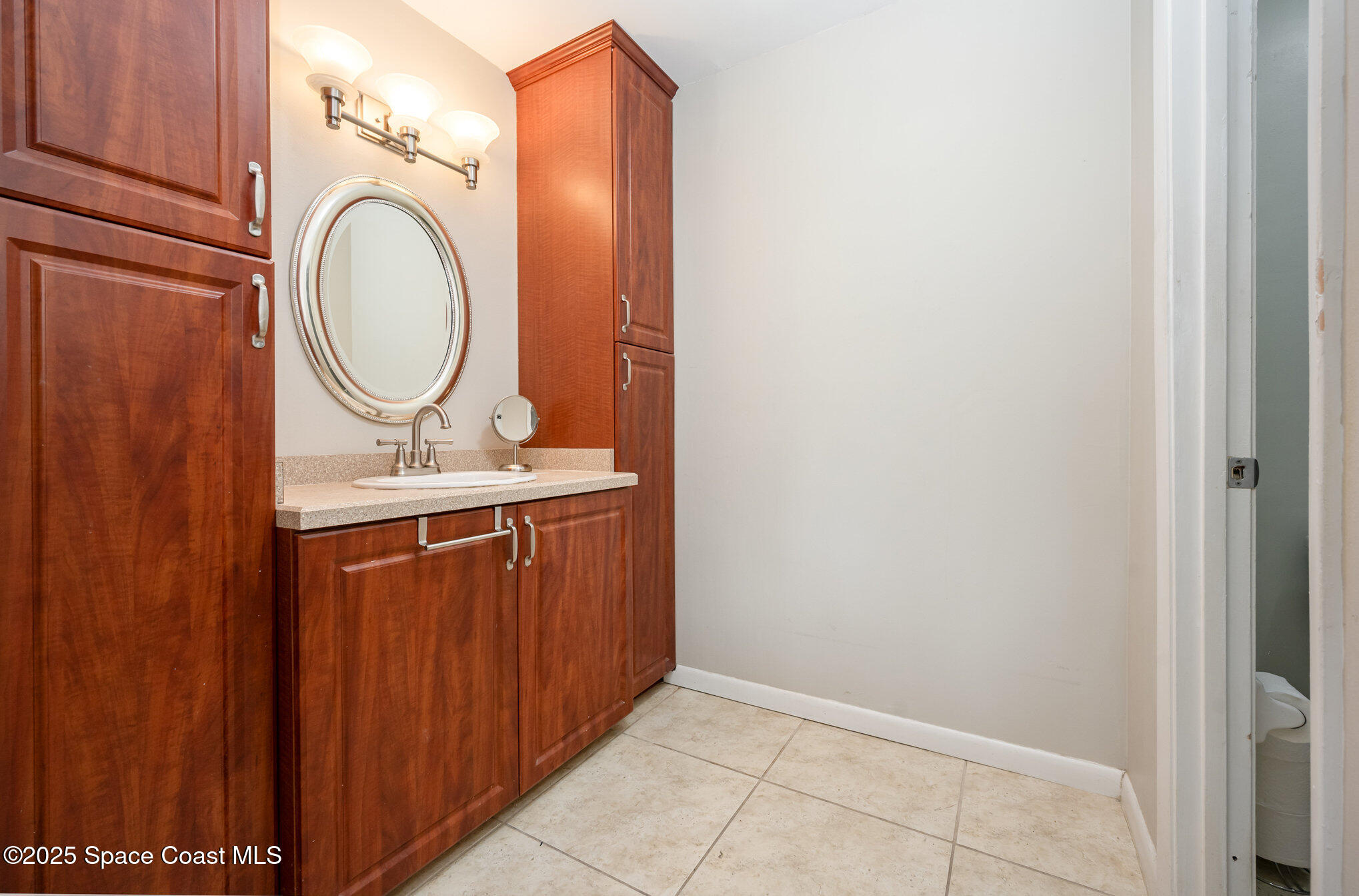 197 Augusta Way Melbourne, FL 32940 - Photo 18 of 37 a bathroom with a sink and a mirror