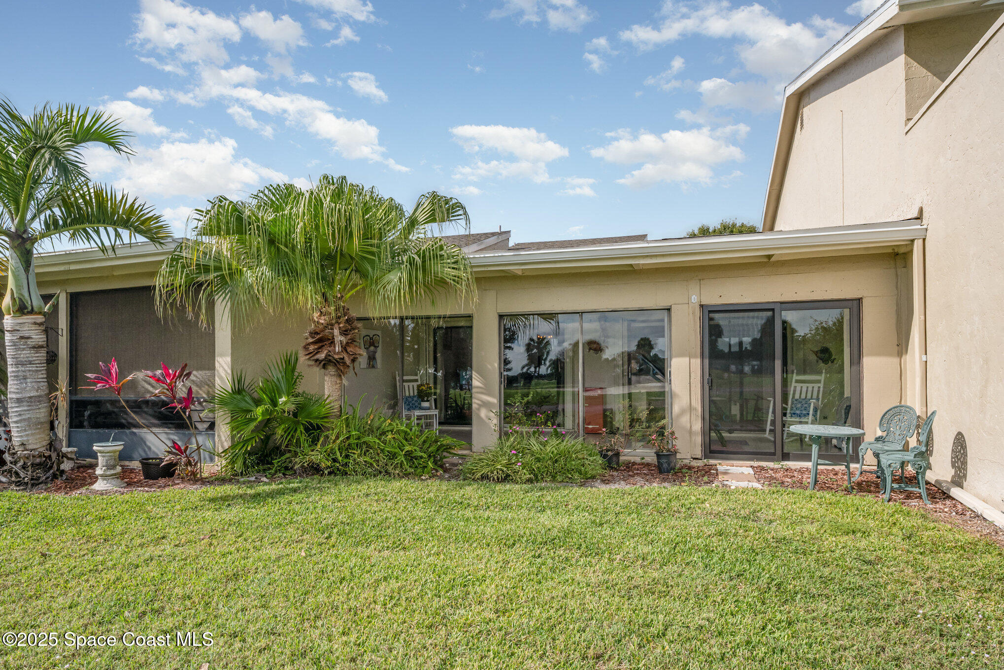 197 Augusta Way Melbourne, FL 32940 - Photo 25 of 37 a view of a house with potted plants and a table