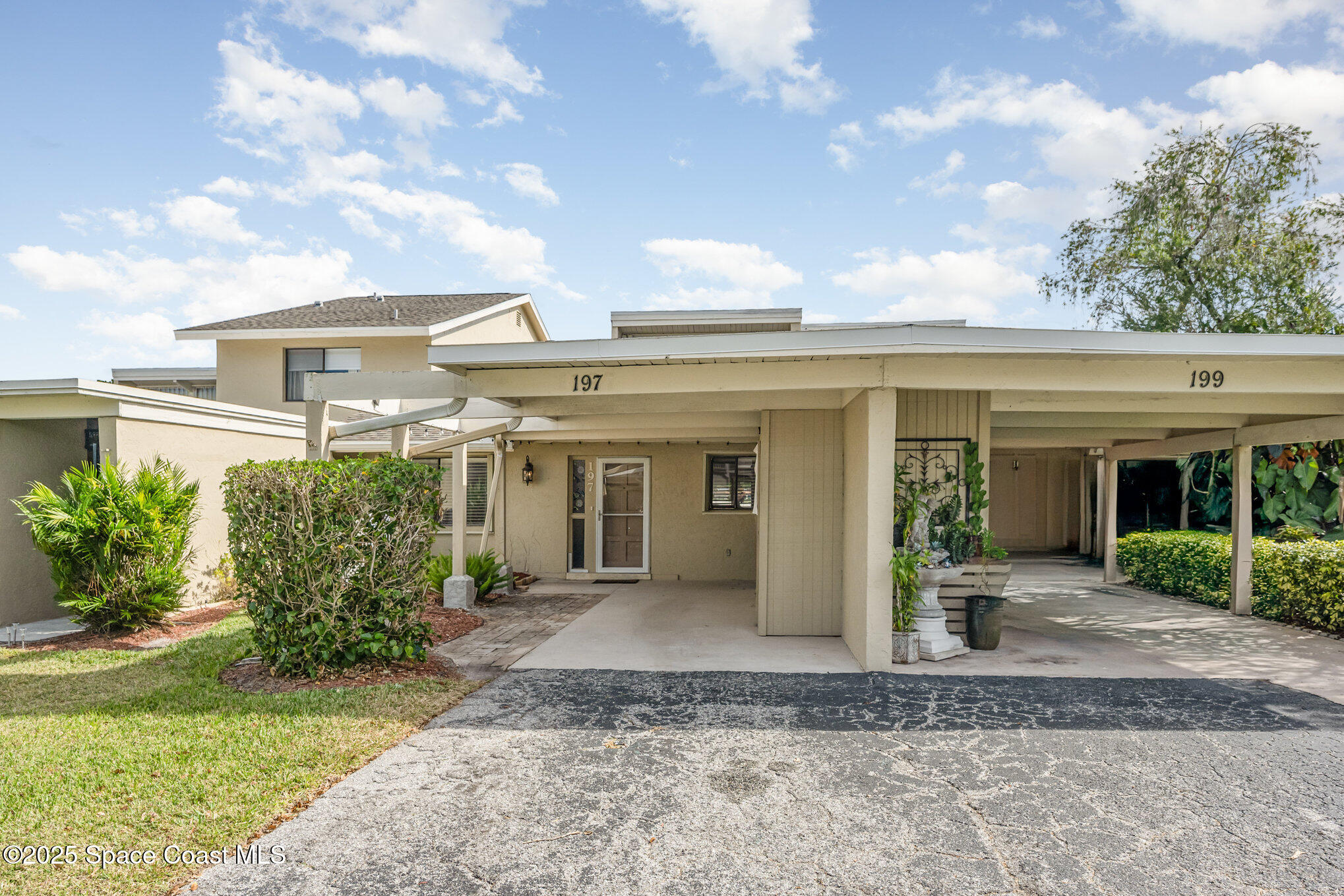 197 Augusta Way Melbourne, FL 32940 - Photo 3 of 37 a view of a house with potted plants and a large tree