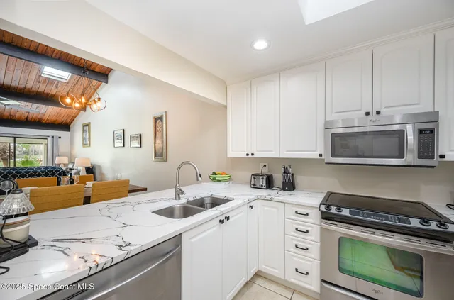 a kitchen with stainless steel appliances granite countertop a sink stove and cabinets