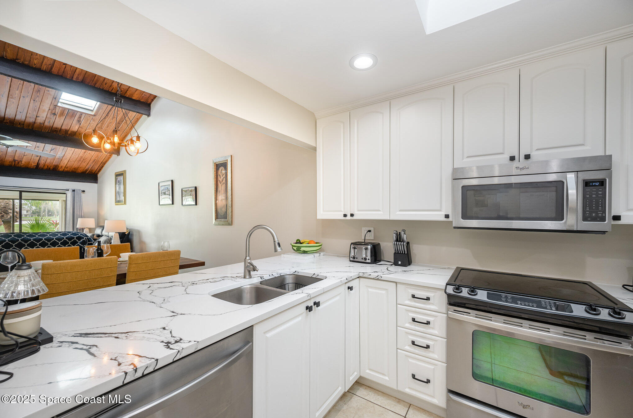 197 Augusta Way Melbourne, FL 32940 - Photo 5 of 37 a kitchen with stainless steel appliances granite countertop a sink stove and cabinets