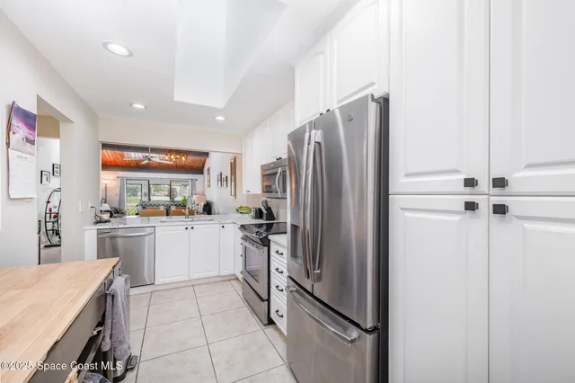 a kitchen with a refrigerator and white cabinets