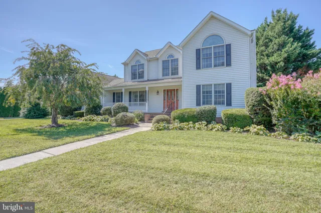 a front view of a house with a yard and trees