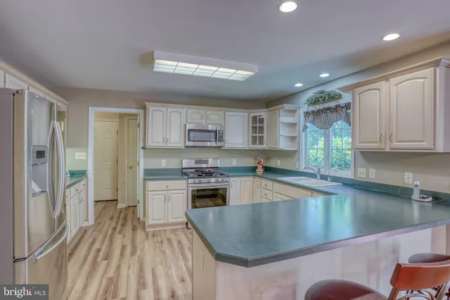 a kitchen with stainless steel appliances granite countertop a stove a sink dishwasher and a microwave oven with cabinets