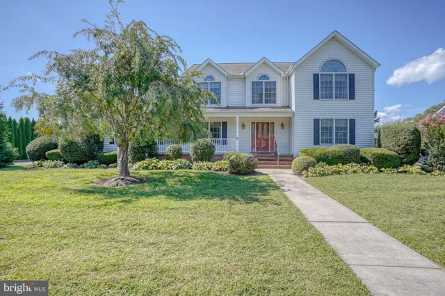 a view of house with a big yard and large trees
