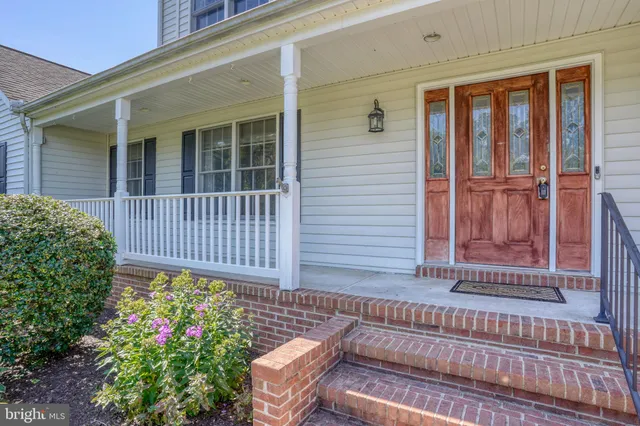 a view of a house with a small yard and wooden floor and fence