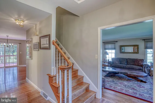 a view of a hallway with wooden floor and staircase