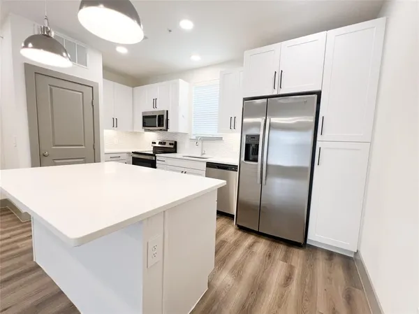 a kitchen with stainless steel appliances a refrigerator sink and microwave