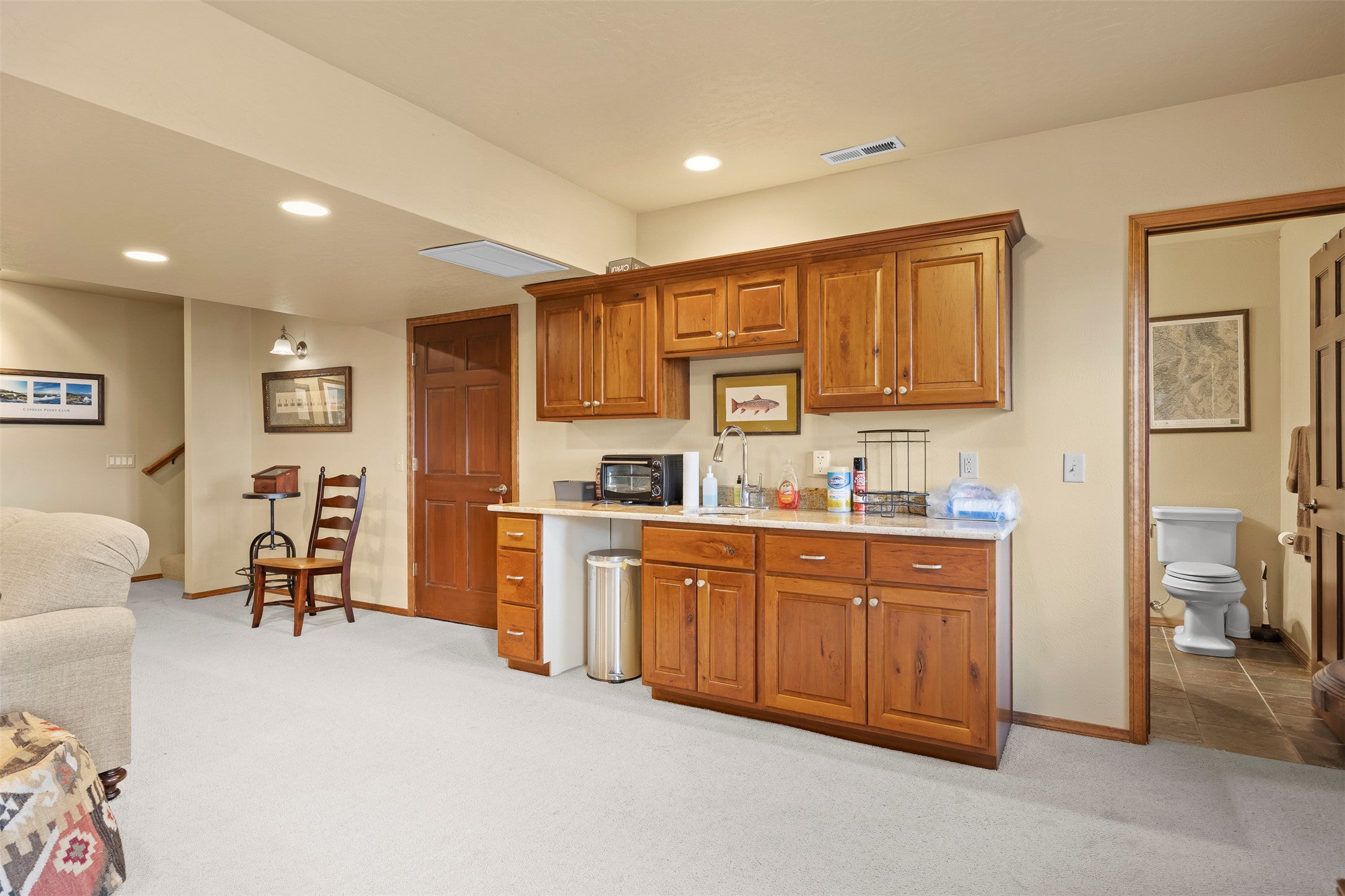730 Big Flat Road Missoula, MT 59804 - Photo 59 of 59 Kitchen with wood finish cabinets, light colored carpet, recessed lighting, open floor plan, and light stone countertops