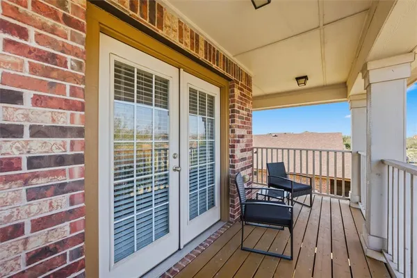 a view of a balcony with chairs and wooden floor