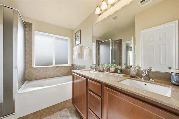 a bathroom with a tub a sink and mirror