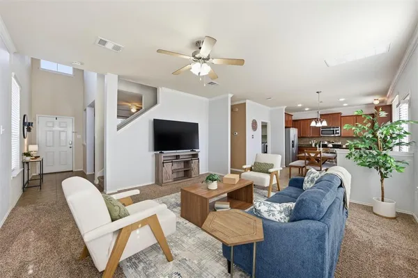 a living room with furniture a chandelier and a flat screen tv