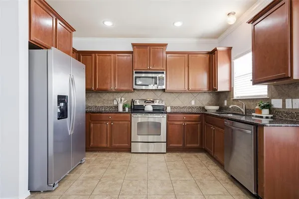 a kitchen with stainless steel appliances granite countertop a refrigerator and a stove top oven