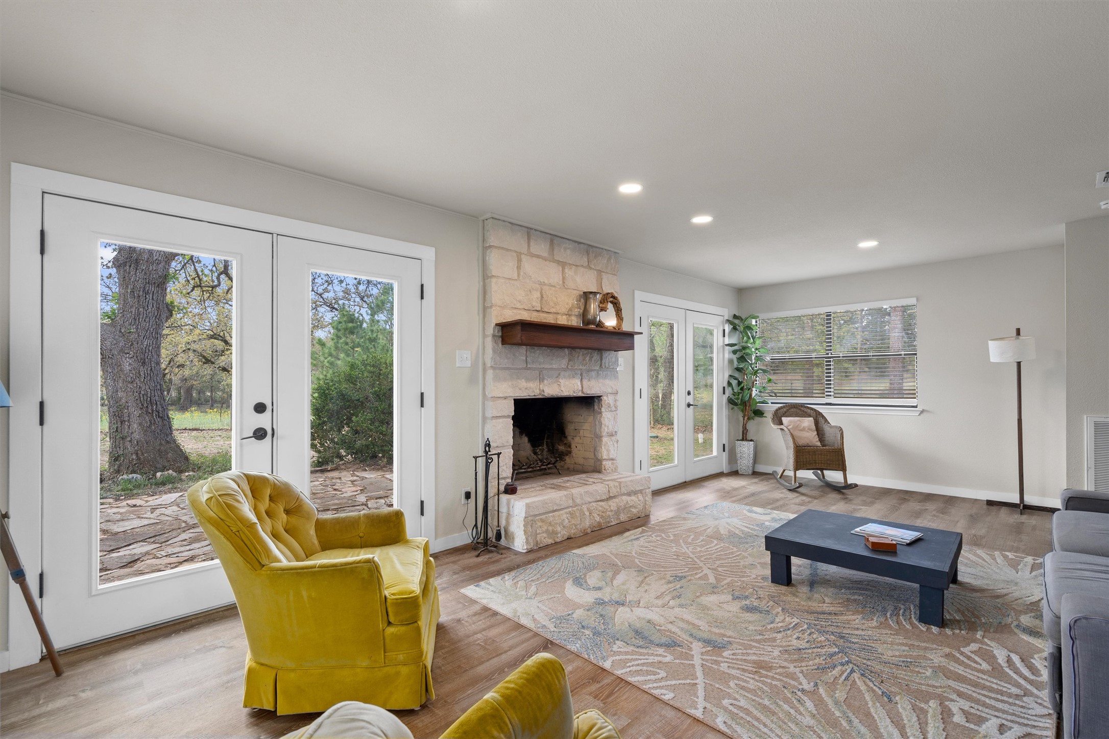 836 Cottle Town Road Smithville, TX 78957 - Photo 12 of 40 Living area with french doors, a fireplace, wood finished floors, and recessed lighting