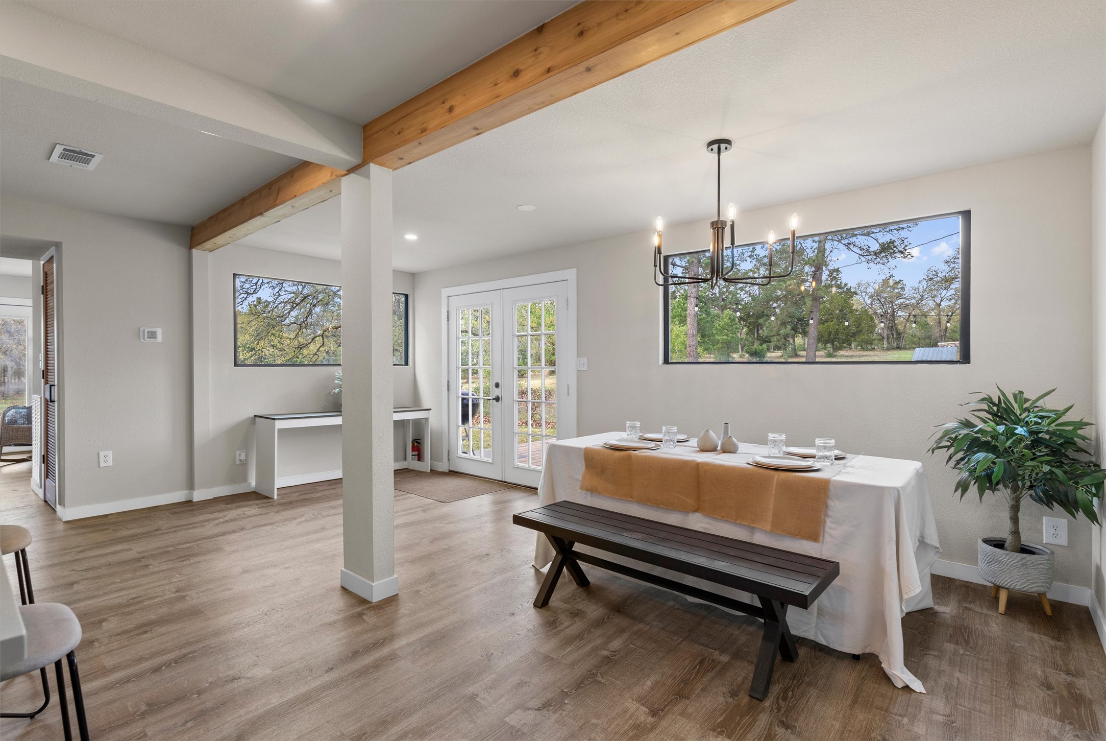 836 Cottle Town Road Smithville, TX 78957 - Photo 15 of 40 Dining room featuring beam ceiling, french doors, wood finished floors, and hanging lights
