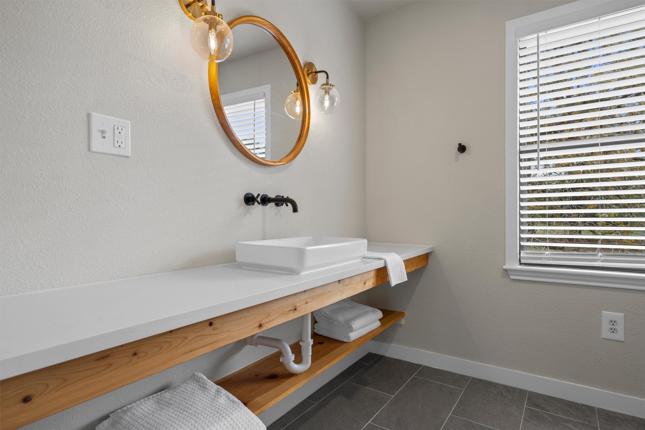 836 Cottle Town Road Smithville, TX 78957 - Photo 28 of 40 Bathroom featuring dark tile patterned floors, vanity, and a textured wall