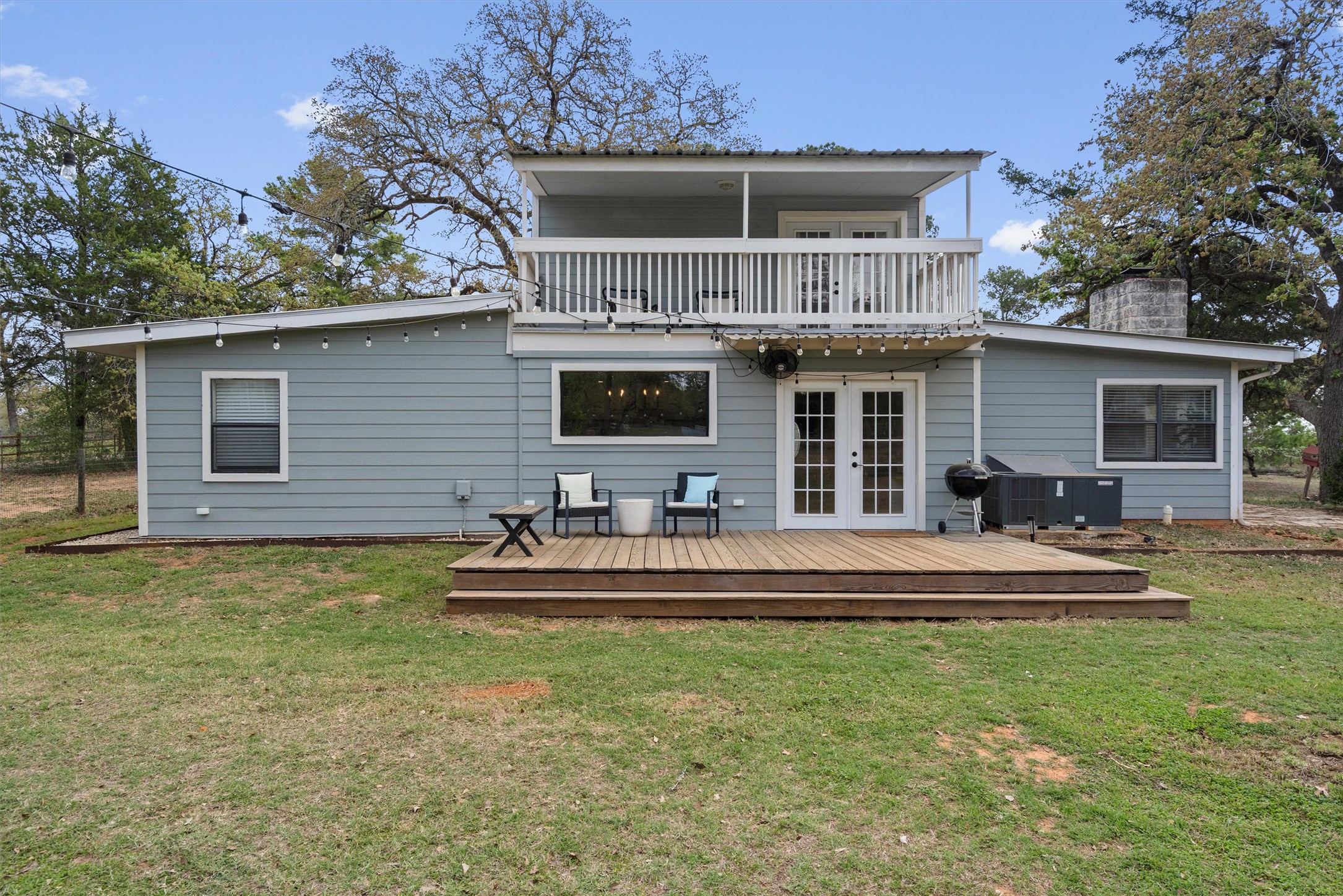 836 Cottle Town Road Smithville, TX 78957 - Photo 32 of 40 Rear view of house featuring french doors, a balcony, a yard, and a chimney