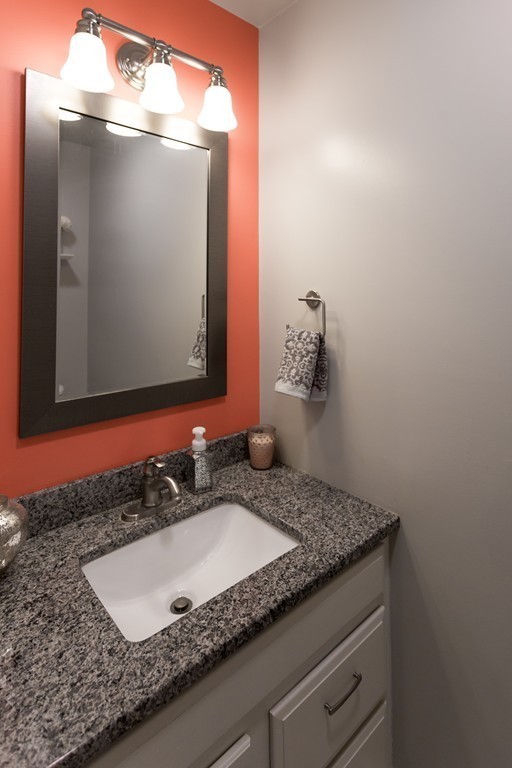 111 Beach Road, Unit 28 Salisbury, MA 01952 - Photo 12 of 14 a bathroom with a granite countertop sink and a mirror