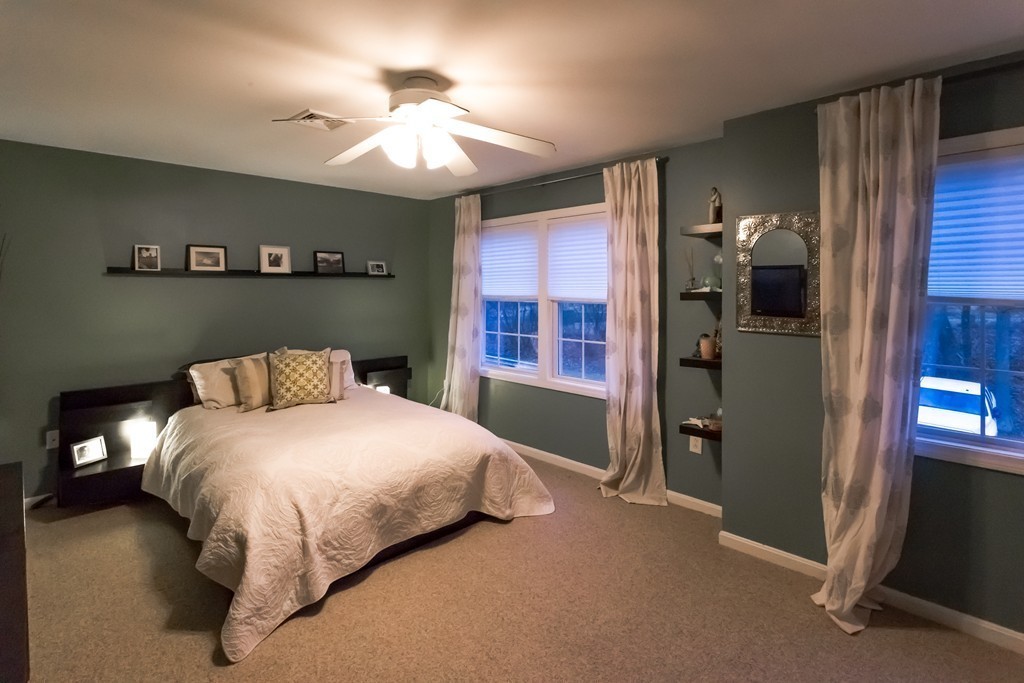 111 Beach Road, Unit 28 Salisbury, MA 01952 - Photo 10 of 14 a bedroom with a bed and a chandelier