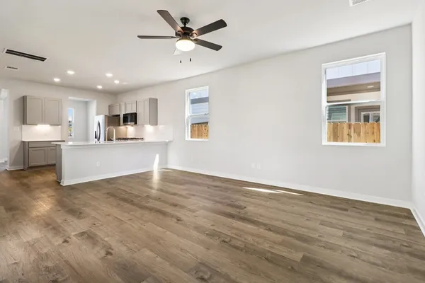 a view of a livingroom with furniture a ceiling fan and wooden floor