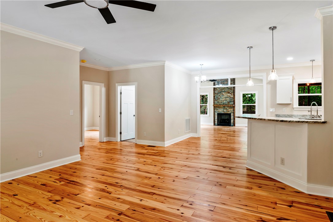 110 Gabriel Way Pickens, SC 29671 - Photo 6 of 48 Natural hardwood flooring flows throughout this open-concept living space, anchored by a stone fireplace.