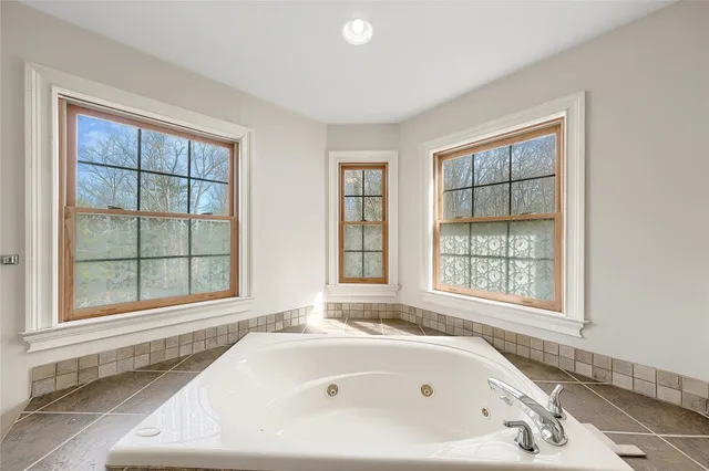 a bathroom with a tub sink and mirror