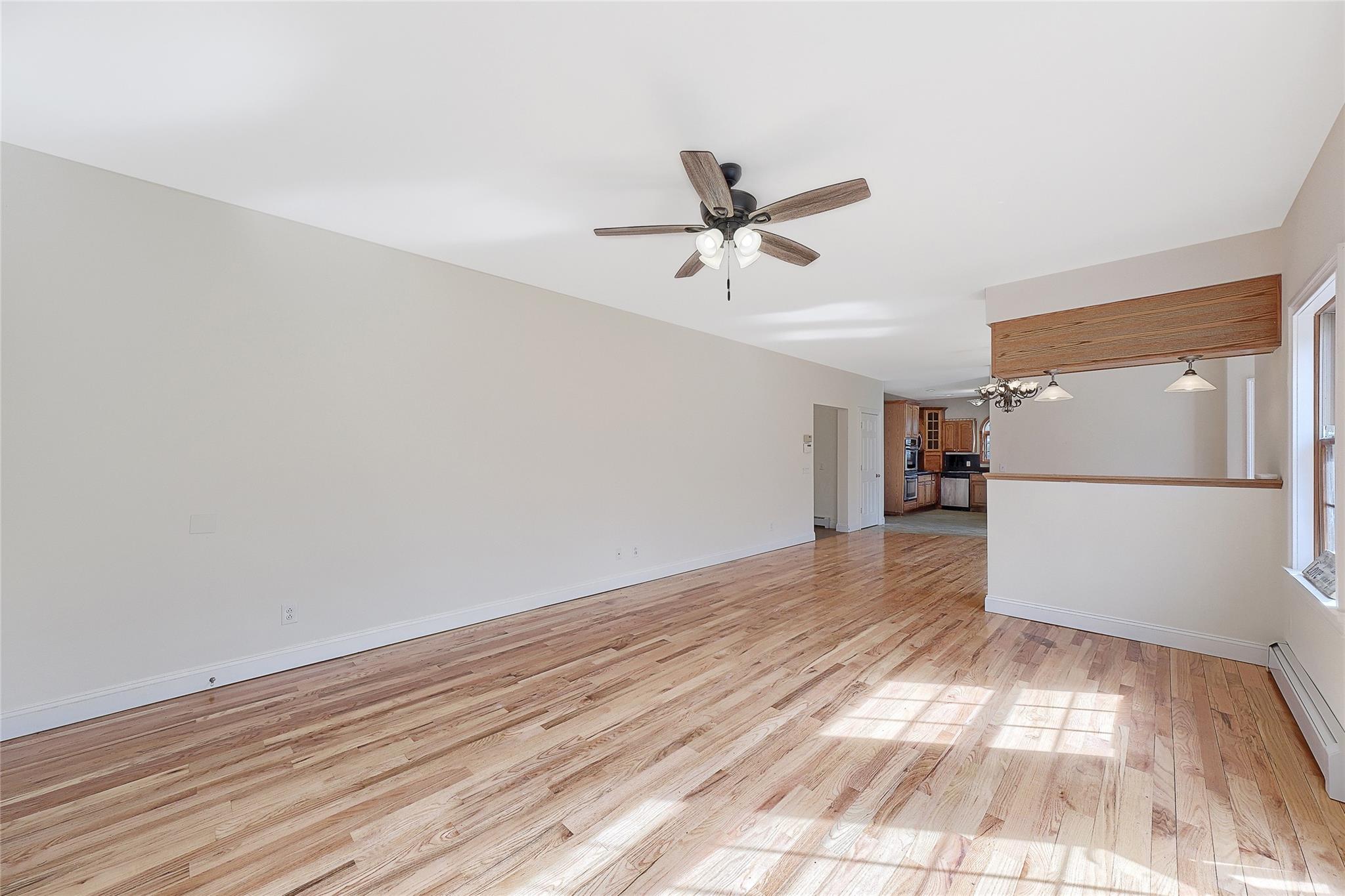 115 E Road Wurtsboro, NY 12790 - Photo 10 of 33 a view of empty room with wooden floor and kitchen view