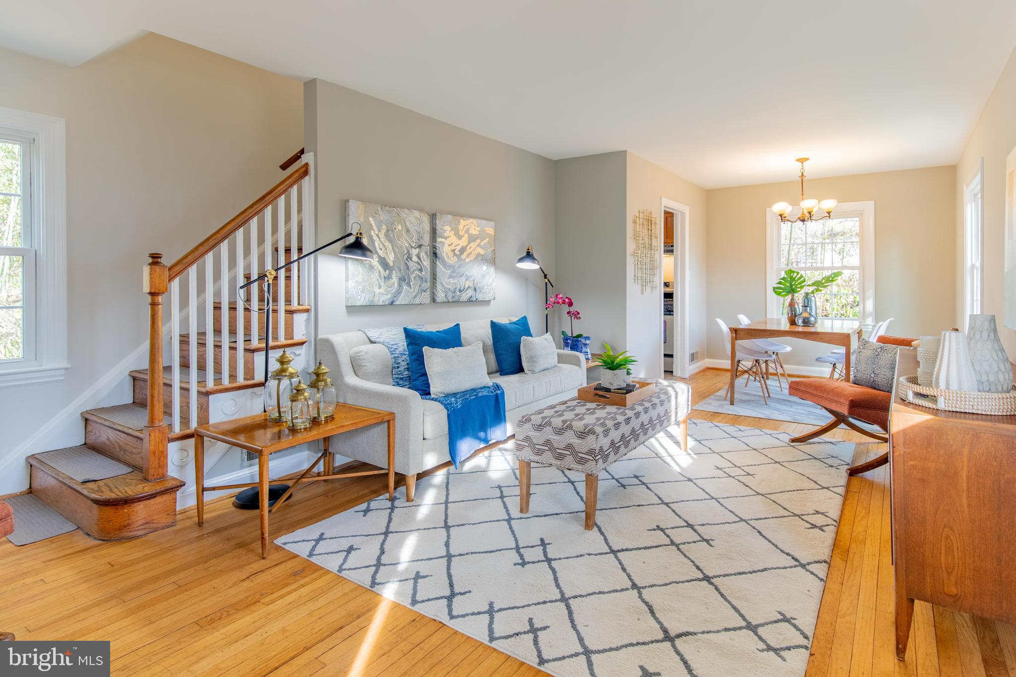 a living room with furniture a wooden floor and next to a window