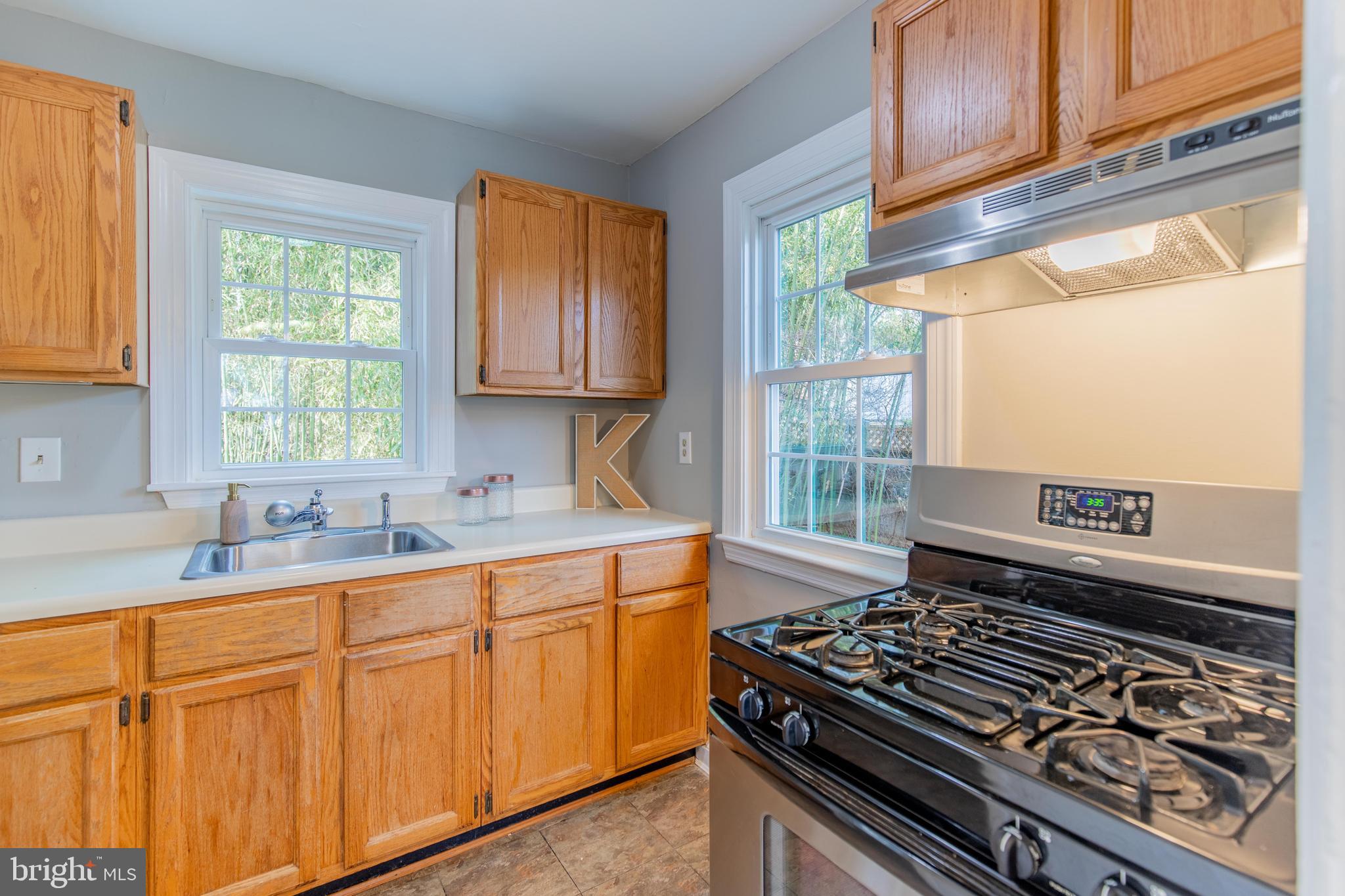 502 East Schuyler Road Silver Spring, MD 20901 - Photo 12 of 29 a kitchen with wooden cabinets stove top oven and sink