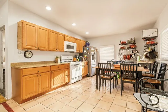 a open kitchen with stainless steel appliances granite countertop a stove a sink a dining table and chairs