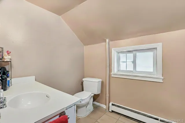 a bathroom with a toilet a sink and a window