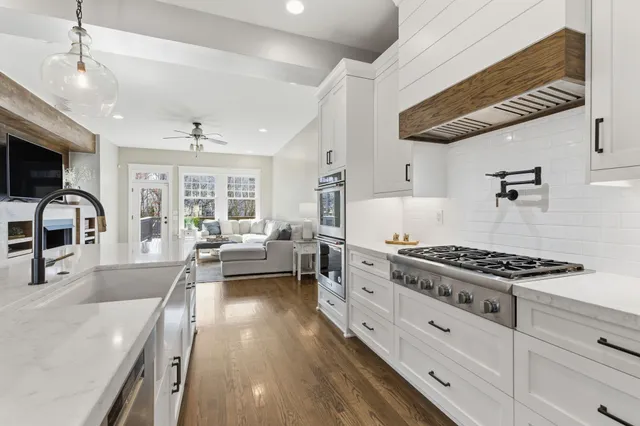 a kitchen with stainless steel appliances granite countertop a stove a sink and a refrigerator