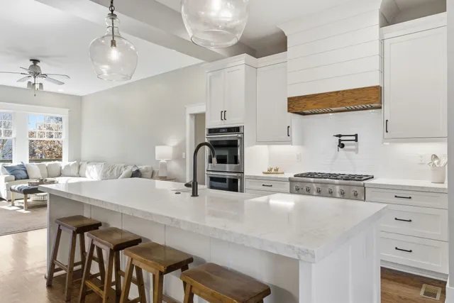 a kitchen with a stove a sink and chairs