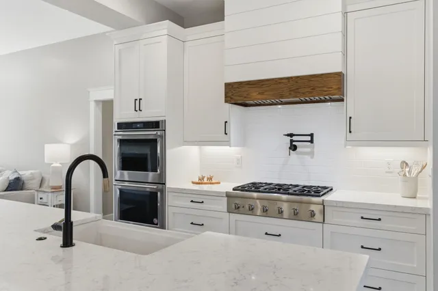 a kitchen with stainless steel appliances kitchen island a white stove top oven and cabinets