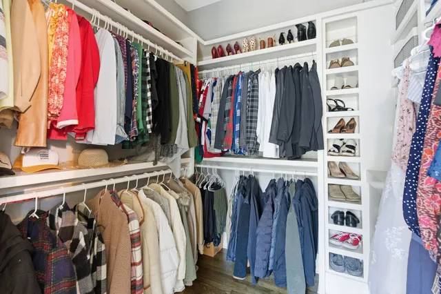 a view of walk in closet with clothes and shoes