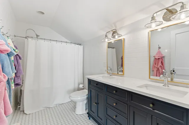 a bathroom with a double vanity sink toilet and shower
