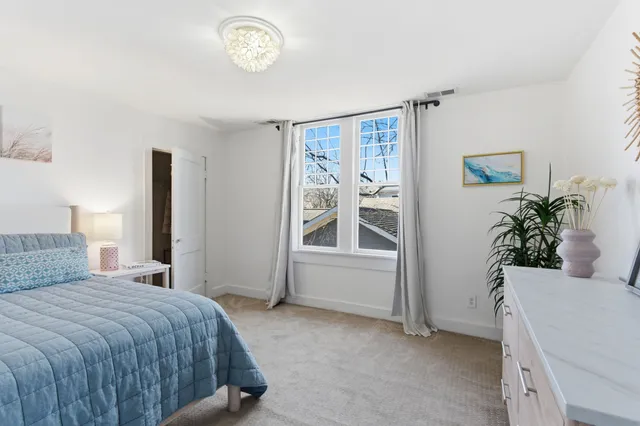 a bedroom with a bed and a potted plant