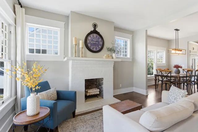a living room with furniture a clock and a fireplace