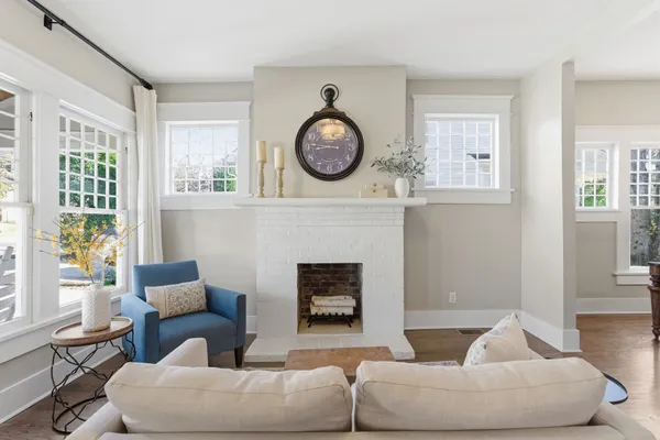 a living room with furniture a fireplace and a large window