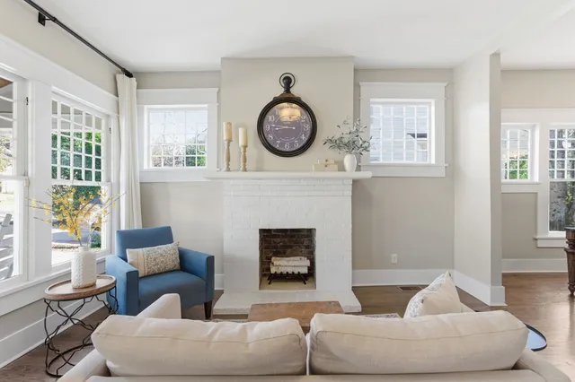 a living room with furniture a fireplace and a large window