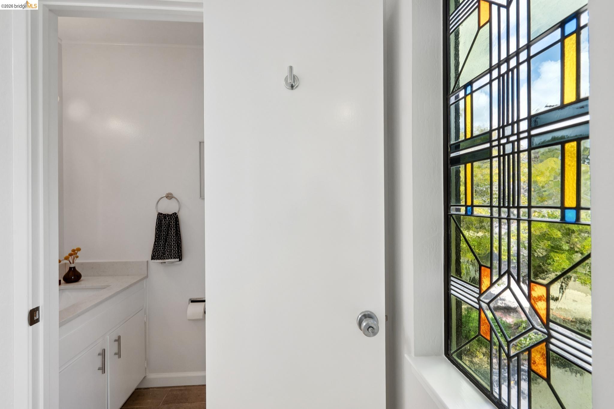 1340 Henry Street Berkeley, CA 94709 - Photo 31 of 52 Decorative stained glass window with a geometric pattern, featuring clear, yellow, orange, and blue glass