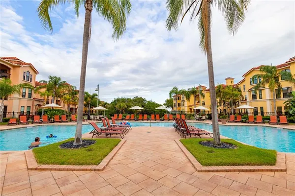 a row of palm trees and swimming pool in the backyard of a house
