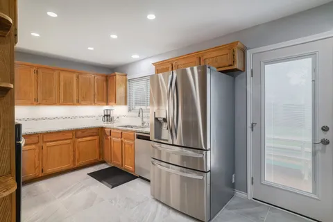a kitchen with stainless steel appliances granite countertop a refrigerator and a sink