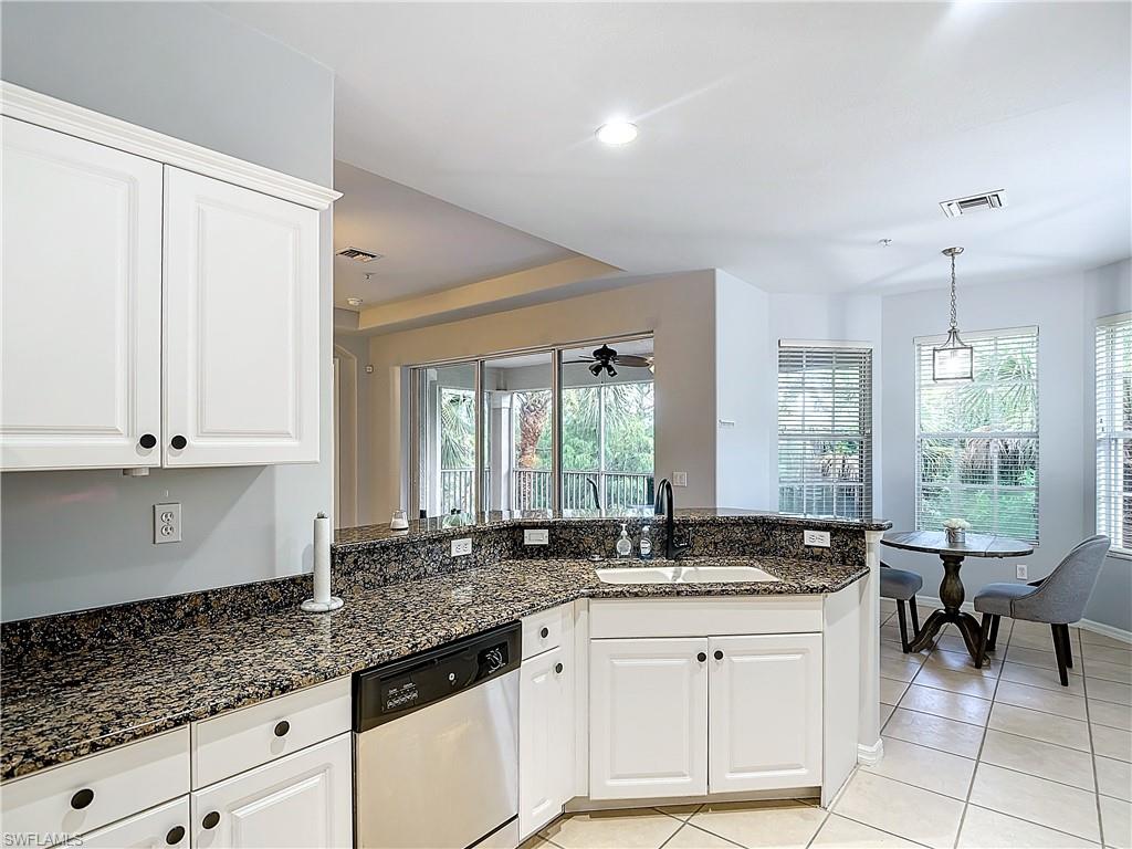 12854 Carrington Circle, Unit 204 Naples, FL 34105 - Photo 12 of 37 a kitchen with granite countertop white cabinets white appliances and a sink