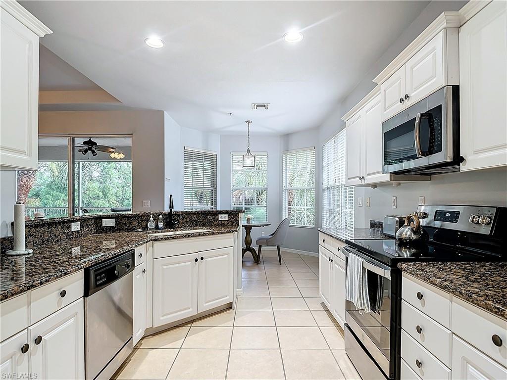 12854 Carrington Circle, Unit 204 Naples, FL 34105 - Photo 13 of 37 a kitchen with stainless steel appliances granite countertop a sink stove and cabinets