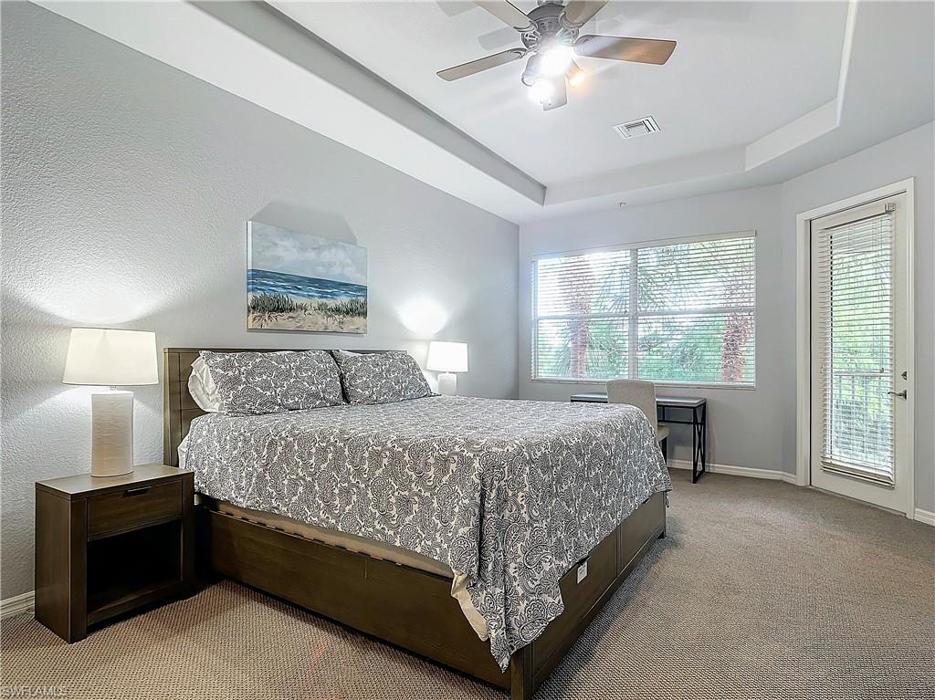 12854 Carrington Circle, Unit 204 Naples, FL 34105 - Photo 14 of 37 a bedroom with a large bed and a chandelier