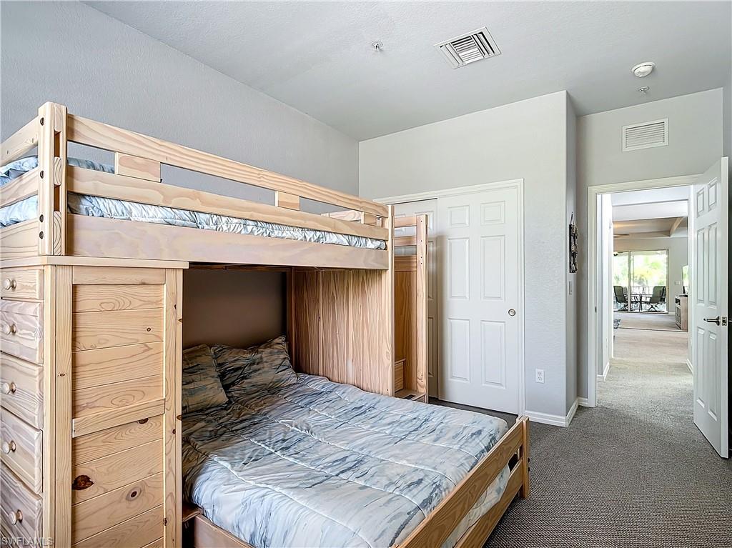 12854 Carrington Circle, Unit 204 Naples, FL 34105 - Photo 15 of 37 a bedroom with a bed and a dresser